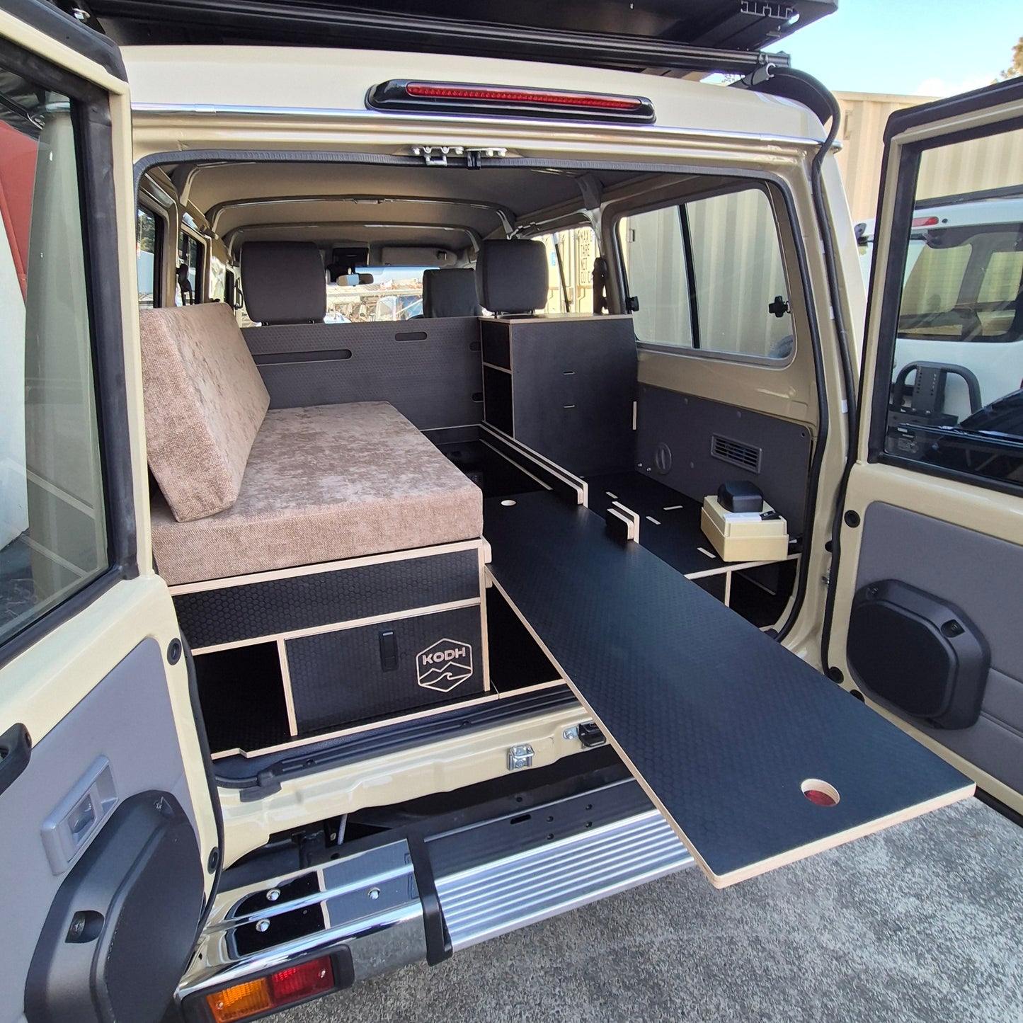 Open van interior with a bed setup on a street