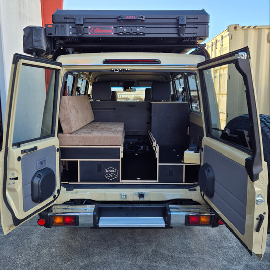 Open van with various compartments and equipment on a clear day.
